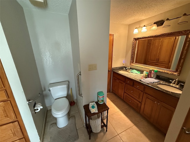 bathroom featuring tile patterned flooring, vanity, a textured ceiling, and toilet