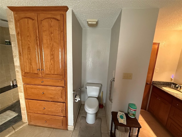 bathroom featuring tile patterned flooring, toilet, a textured ceiling, and vanity