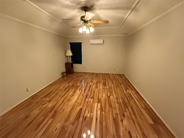 unfurnished living room with a ceiling fan, a wall mounted AC, a textured ceiling, wood finished floors, and crown molding