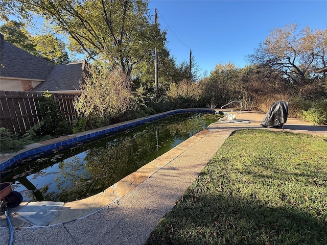 view of pool featuring a yard, fence, and a fenced in pool