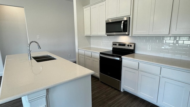 kitchen with sink, stainless steel appliances, dark hardwood / wood-style flooring, a kitchen island with sink, and white cabinets