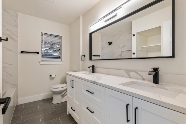 bathroom with tile patterned floors, vanity, a tile shower, and toilet