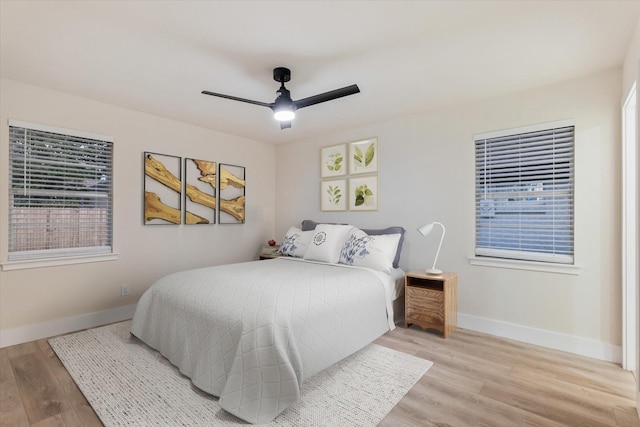 bedroom featuring multiple windows, light hardwood / wood-style floors, and ceiling fan