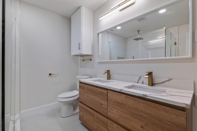 bathroom with tile patterned floors, toilet, vanity, and walk in shower