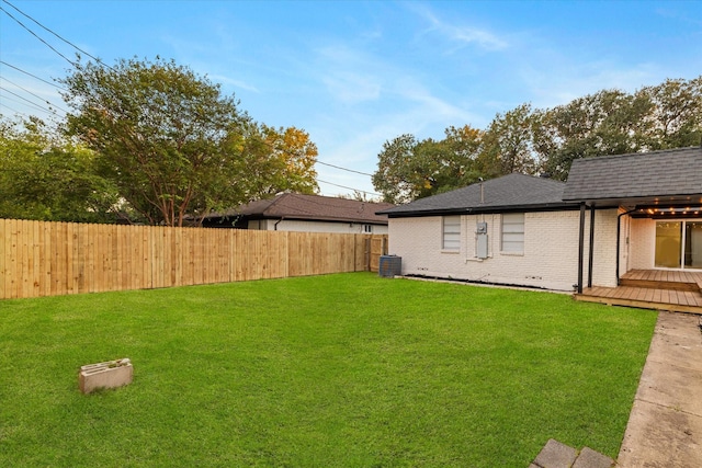 view of yard featuring central AC unit and a wooden deck