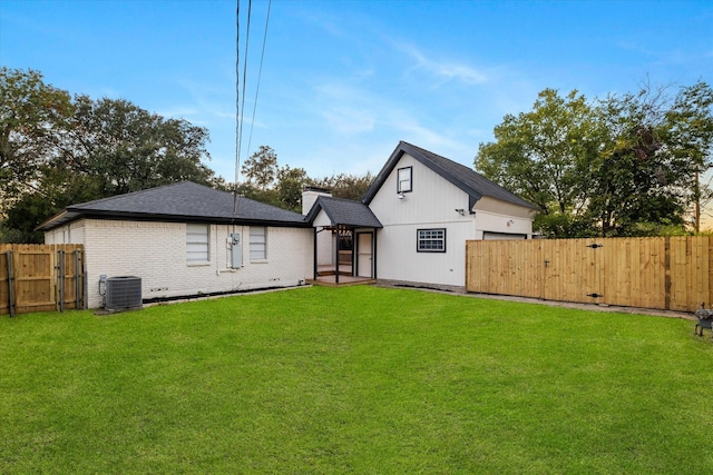 back of house featuring a lawn and cooling unit