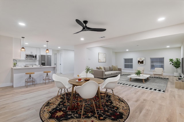 living room with ceiling fan, sink, and light hardwood / wood-style flooring