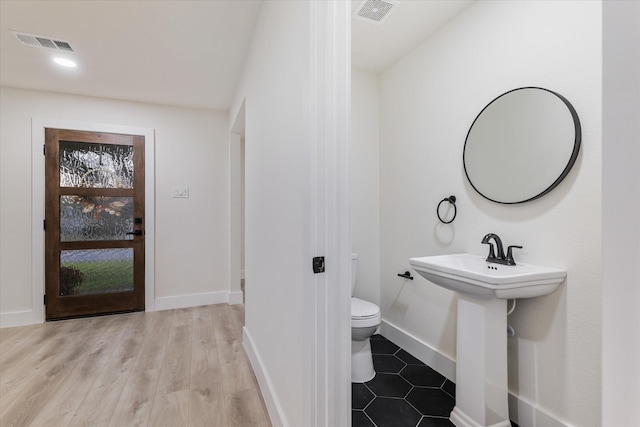 bathroom with sink, hardwood / wood-style floors, and toilet