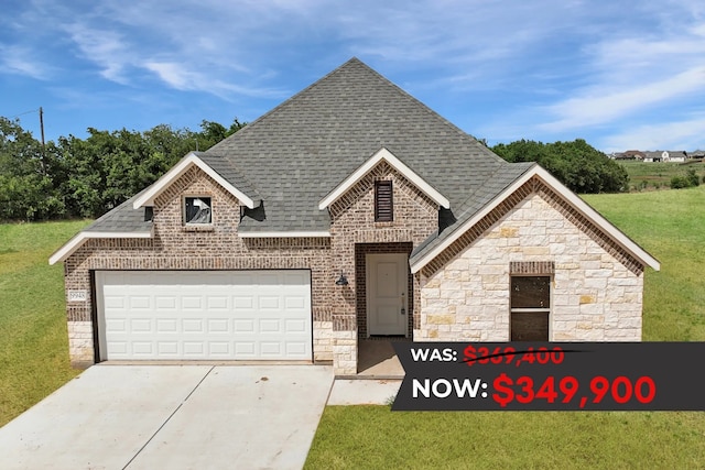 view of front of property with a front yard and a garage