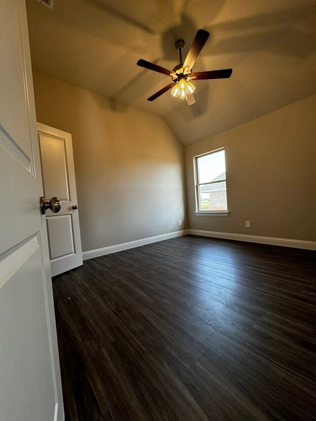 empty room with dark hardwood / wood-style floors, ceiling fan, and lofted ceiling