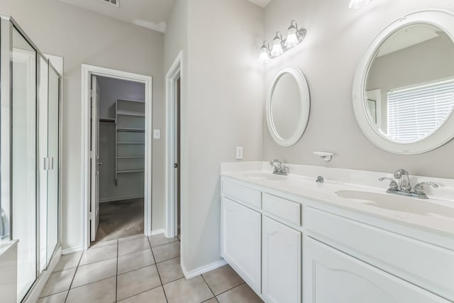 bathroom featuring tile patterned flooring, vanity, and an enclosed shower