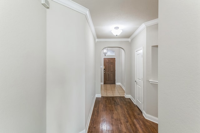 entryway with ornamental molding and dark wood-type flooring