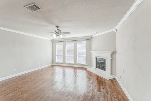 unfurnished living room featuring a textured ceiling, ceiling fan, wood-type flooring, and crown molding