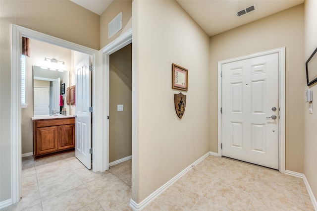 entrance foyer featuring sink and light tile patterned flooring