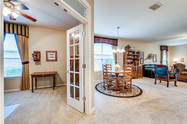 tiled dining space featuring ceiling fan with notable chandelier and a healthy amount of sunlight