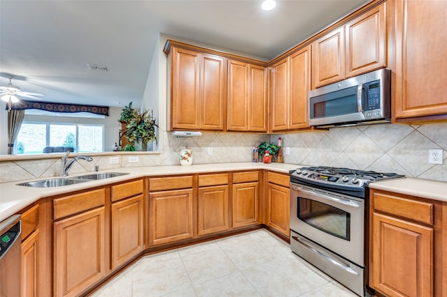 kitchen featuring decorative backsplash, stainless steel appliances, ceiling fan, sink, and light tile patterned floors