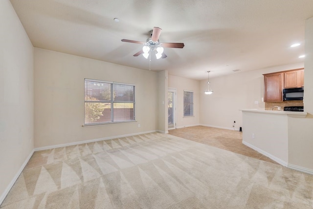 unfurnished living room featuring baseboards, ceiling fan, recessed lighting, and light colored carpet