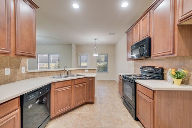 kitchen with black appliances, a healthy amount of sunlight, sink, and pendant lighting