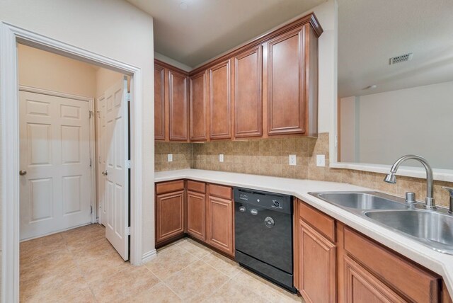 kitchen featuring light tile patterned flooring, a sink, a peninsula, tasteful backsplash, and black appliances