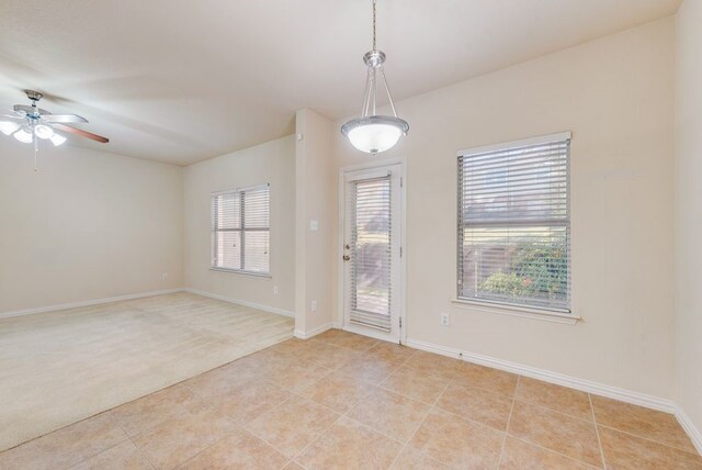 empty room with baseboards, light carpet, a ceiling fan, and visible vents
