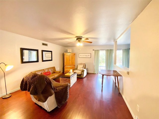 living room featuring dark wood-type flooring and ceiling fan