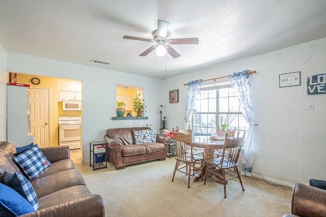 carpeted living room with ceiling fan