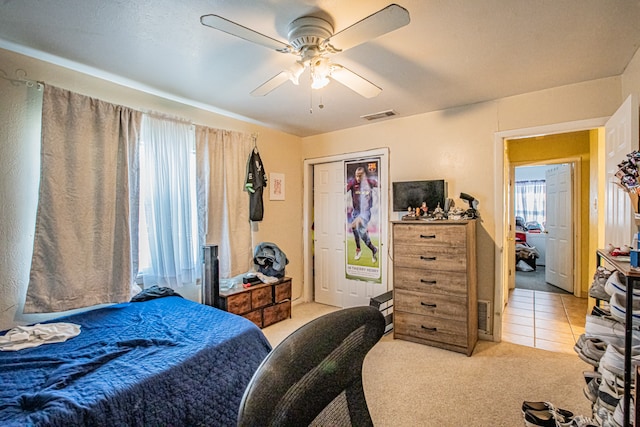 bedroom with light carpet, a closet, and ceiling fan