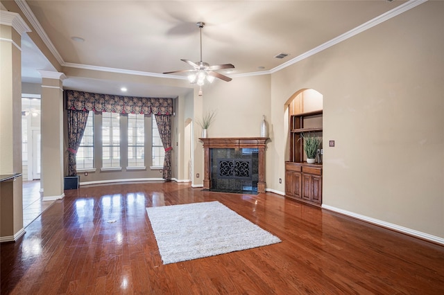 unfurnished living room featuring a premium fireplace, ceiling fan, dark wood-type flooring, and ornamental molding