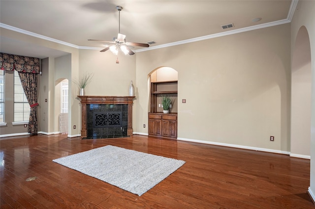 unfurnished living room featuring ceiling fan, crown molding, dark wood-type flooring, and a high end fireplace