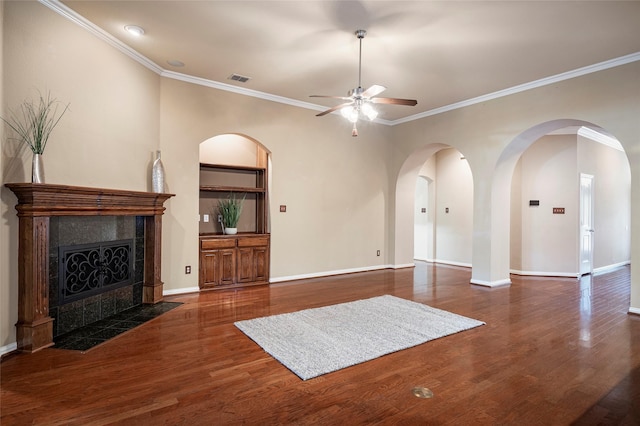 unfurnished living room featuring a fireplace, ceiling fan, dark hardwood / wood-style flooring, and ornamental molding