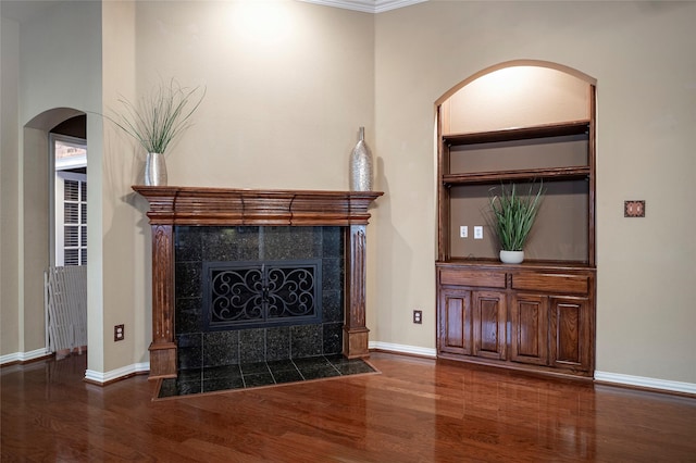 unfurnished living room featuring a fireplace, dark hardwood / wood-style floors, and ornamental molding