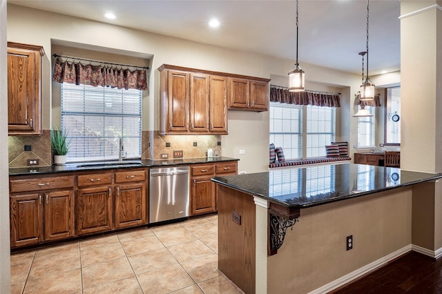 kitchen featuring sink, stainless steel dishwasher, a kitchen island, tasteful backsplash, and light tile patterned flooring