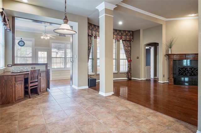 dining space with ceiling fan, decorative columns, light hardwood / wood-style floors, built in desk, and ornamental molding