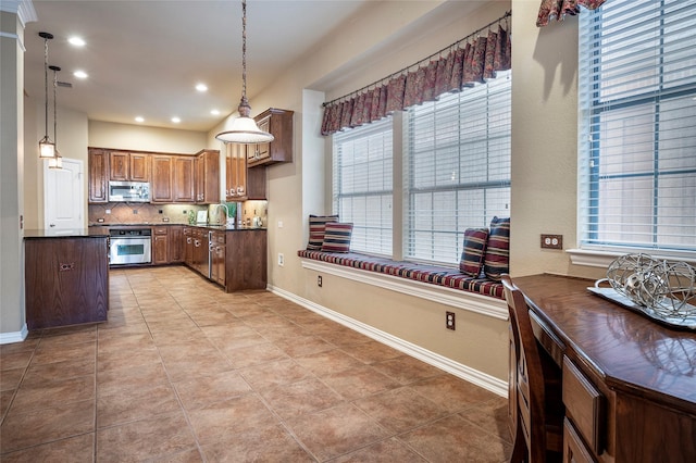 kitchen with tasteful backsplash, hanging light fixtures, light tile patterned floors, and stainless steel appliances