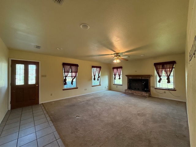 unfurnished living room featuring ceiling fan, light tile patterned flooring, and a wealth of natural light