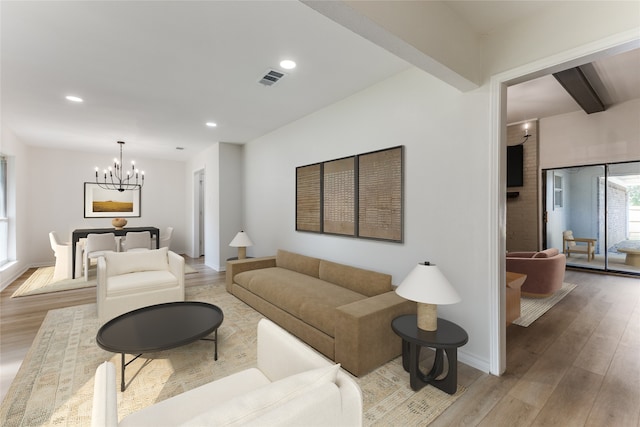 living room with light wood-type flooring, a chandelier, and beam ceiling