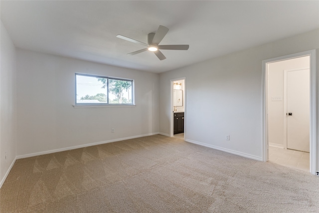 spare room with ceiling fan and light colored carpet