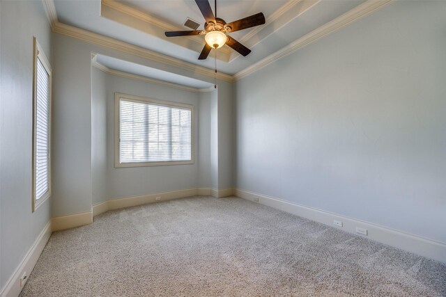 empty room with crown molding, carpet flooring, ceiling fan, and a tray ceiling