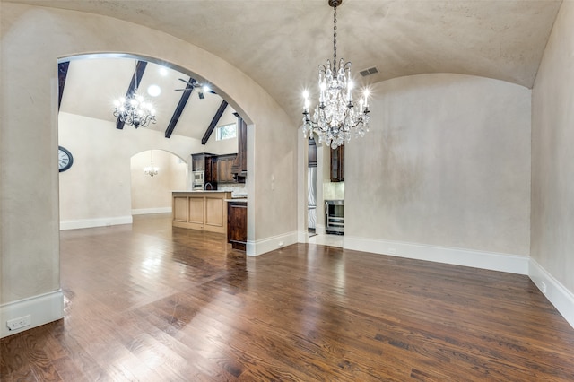 unfurnished dining area with lofted ceiling, dark wood-type flooring, and ceiling fan with notable chandelier