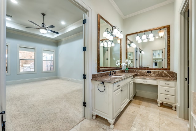 bathroom with crown molding, vanity, ceiling fan, and a tray ceiling