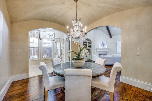 4122 Walnut Meadow Ln, Dallas, TX 75229 - dining area with lofted ceiling, built in shelves, arched walkways, baseboards, and wood finished floors