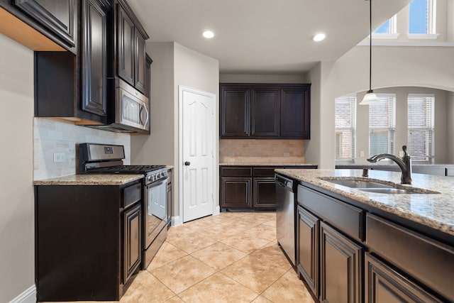 kitchen with backsplash, a wealth of natural light, sink, and appliances with stainless steel finishes