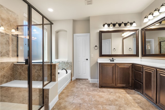 bathroom with vanity and separate shower and tub