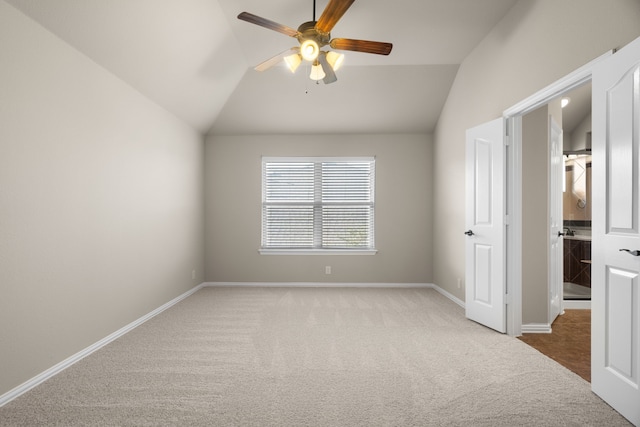 empty room with carpet, ceiling fan, and vaulted ceiling