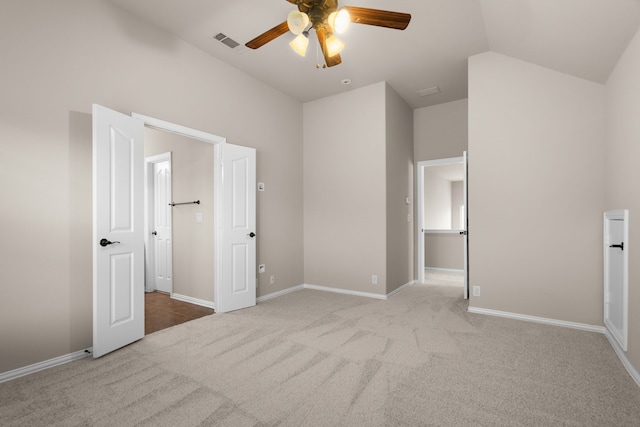 unfurnished bedroom featuring ceiling fan, light colored carpet, and lofted ceiling