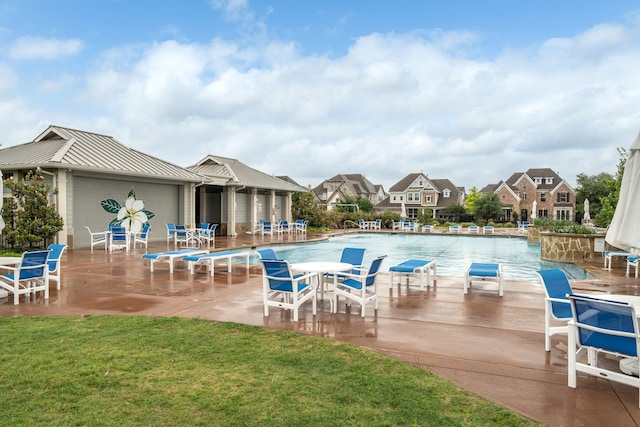 view of pool with a lawn and a patio area