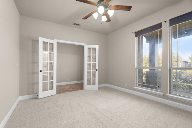 carpeted spare room featuring french doors and ceiling fan