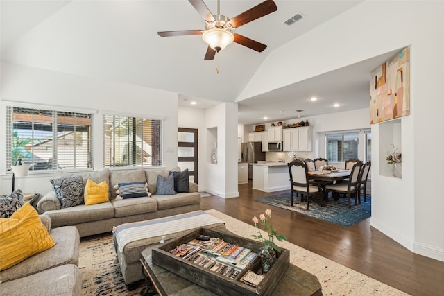 living room with dark hardwood / wood-style floors, high vaulted ceiling, and ceiling fan