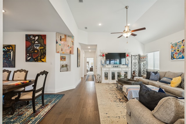 living room with dark hardwood / wood-style floors, ceiling fan, and vaulted ceiling