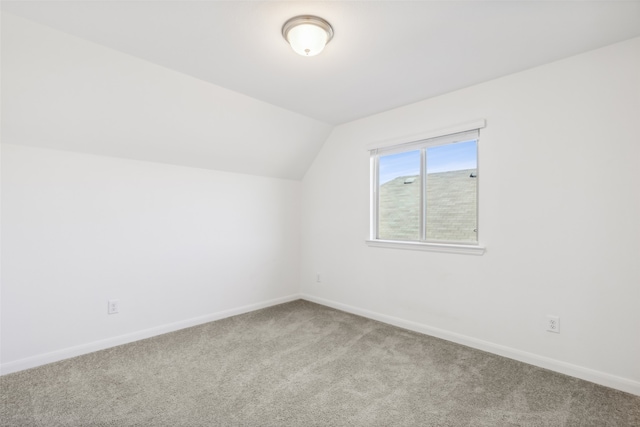 additional living space featuring light colored carpet and lofted ceiling